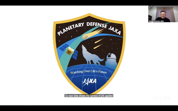 Screenshot from the talk, showing the "Planetary Defense JAXA" logo. It is in the shape of shield, and shows a silhouette of a wolf howling at a night sky with incoming meteors. The Hayabusa2 spacecraft and a ground-based telescope are also in the image. WOLF stands for "Watching Over Life's Future". 