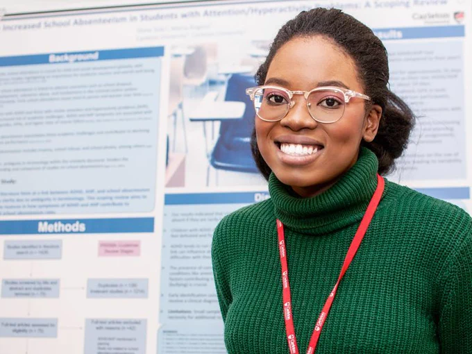 A student smiling in front of their poster presentation at the I-CUREUS and SaPP Showcase.