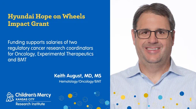 This graphic is on a medium blue background. On the right is a portrait of Keith August, MD, MS, Hematology/Oncology/BMT. He is wearing glasses and a light blue thin plain button-up shirt. On the left is text that describes who he received funding from and for what it will be used for: ‘Hyundai Hope on Wheels’ Grant. Funding supports the salaries of two regulatory cancer research coordinators for Oncology, Experimental Therapeutics and BMT. 