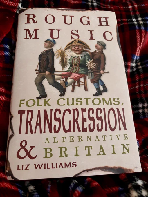 A book lying on a tartan blanket. The book is called Rough Justice folk customs, transgressions and alternative Britain by Liz Smith. The cover shows boys carrying an elaborate bonfire night Guy. 