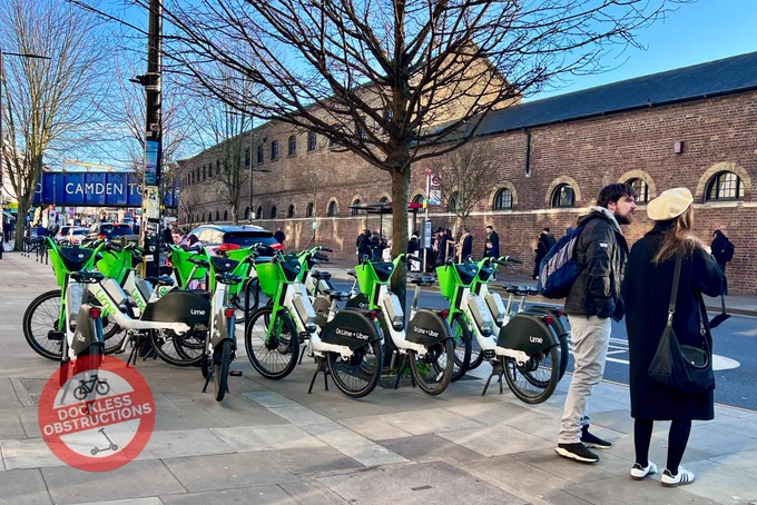 A large cluster of Lime bikes parked across a pavement outside Camden Market.
