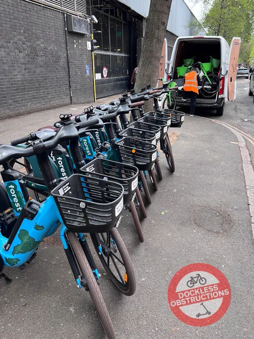 Row of Forest hire bikes deployed on pavement.