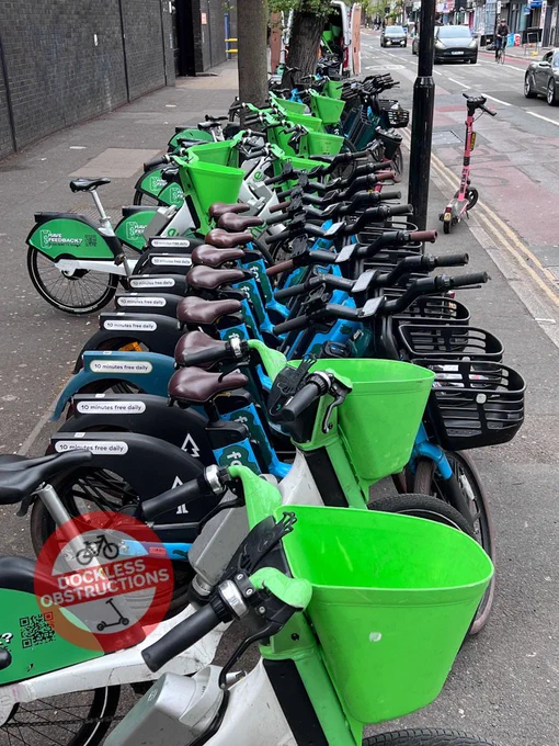 Rows of Forest bikes deployed on pavement for hire surrounded by lime bikes.