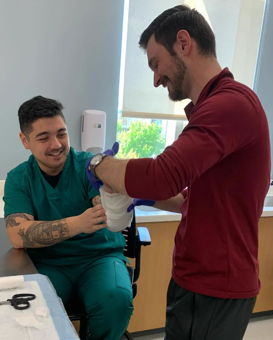 Two physician assistant program students practice arm splinting. 