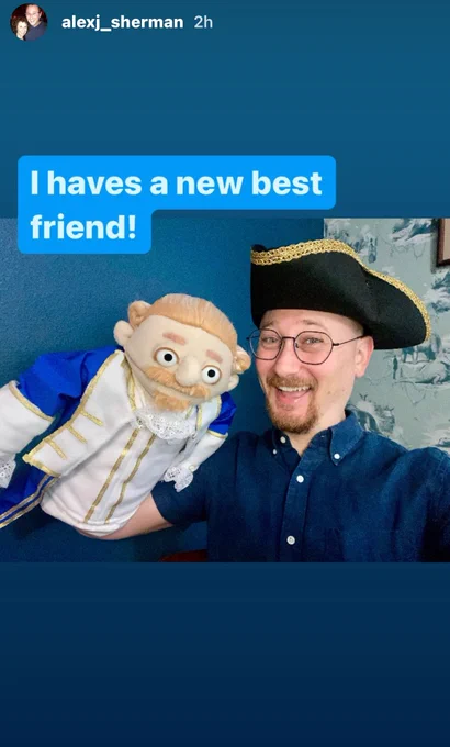 Alex Sherman stands in a blue shirt wearing a black pirate hat and holding his AssTonight Doppleganger in muppet form. Words written "I haves a new best friend!"