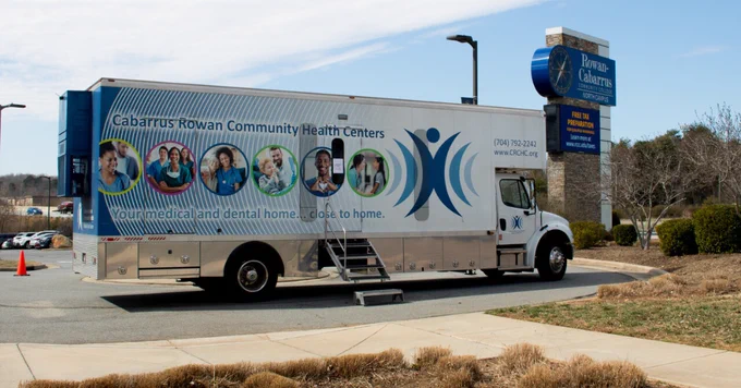 Mobile health clinic from Cabarrus Rowan Community Health Centers parked at Rowan-Cabarrus North Campus, promoting local medical and dental care.