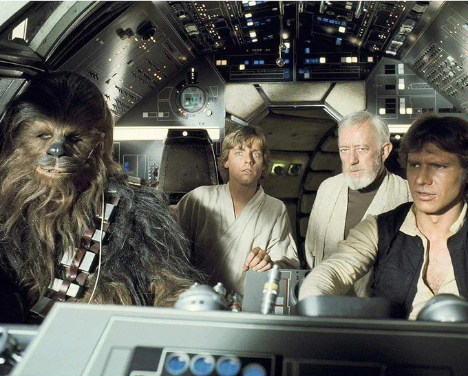 A still from Star Wars showing three people and Chewbacca, sitting inside a spacecraft