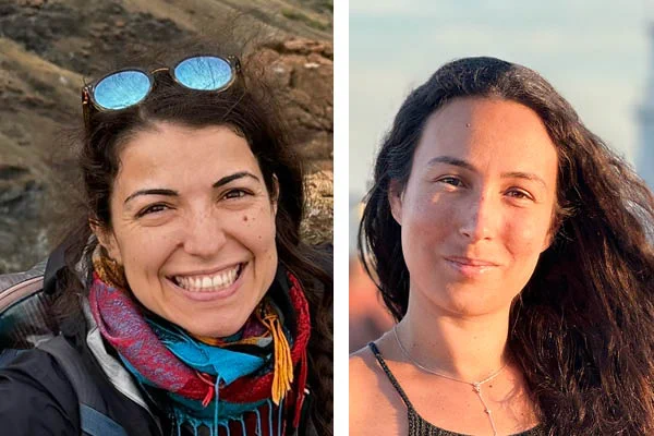 Photograph of two women smiling - one on the left has glasses on top of her head and is standing in front of a rock formation, one on right has long brown hair and is pictured in an outside location