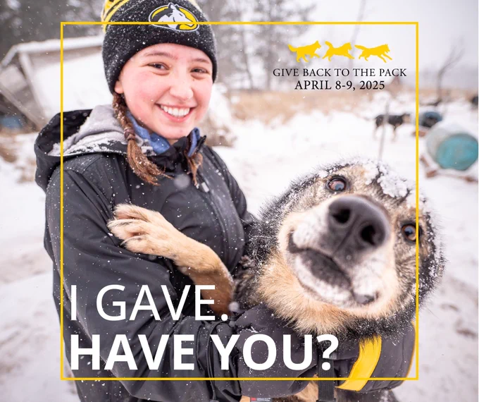 A member of MTU's Mushing Team with one of the sled dogs.