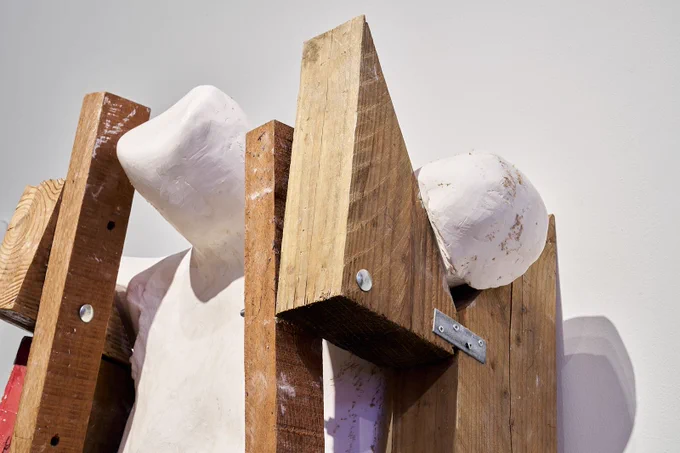Wooden shapes holding up a plaster cast of a body.