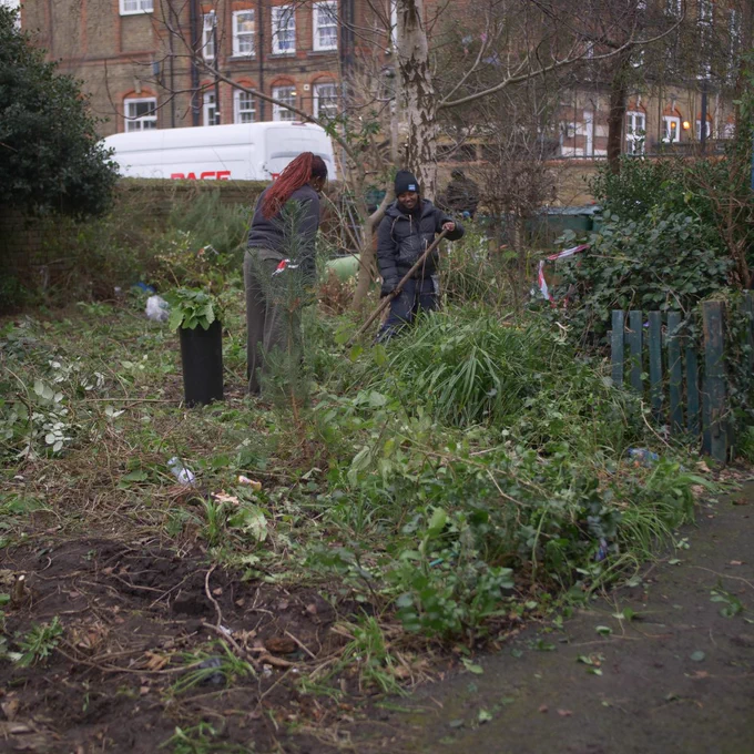 2 females tending a very overgrown garden
