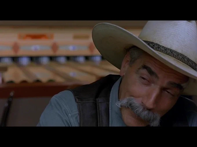 The Stranger turns his head towards the unseen bartender as the camera pans away from him and the movie ends.