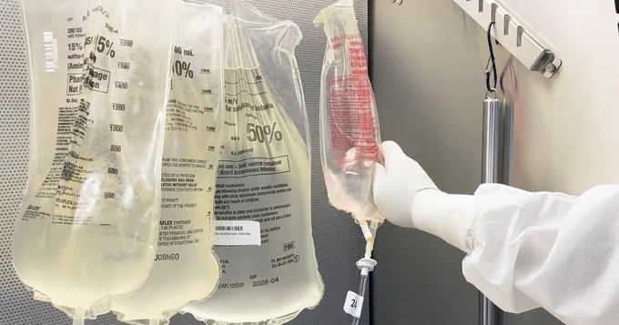 IV bags in a clinical setting with a health care professional handling them.