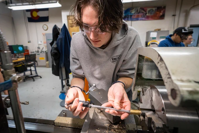 A male student using measuring tools. 