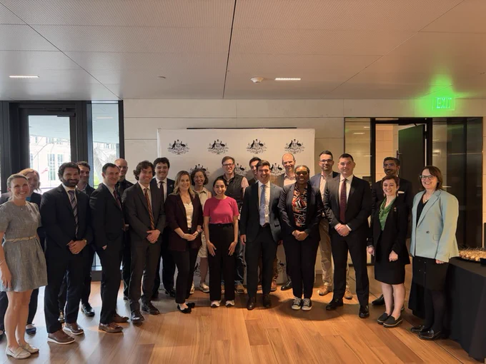 22 individuals from think tanks, the Embassy, and Congress standing at the Australian Embassy smiling as a group.