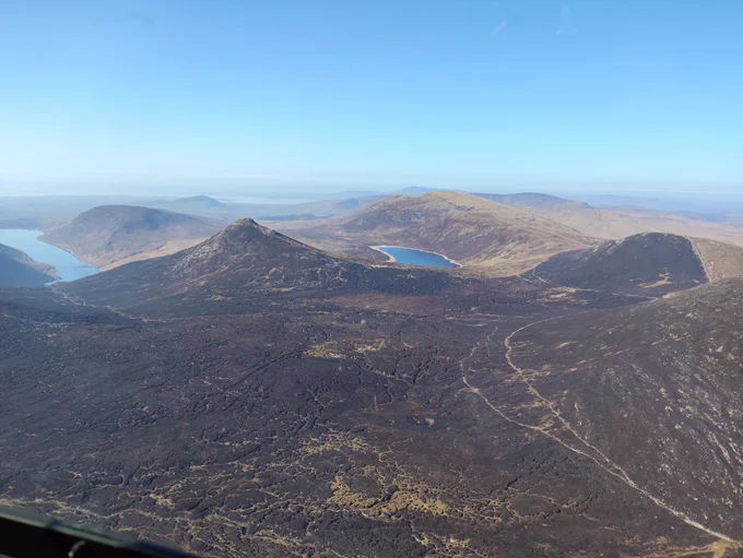 A picture from the air of dark ground caused by fire in the Mourne mountains.