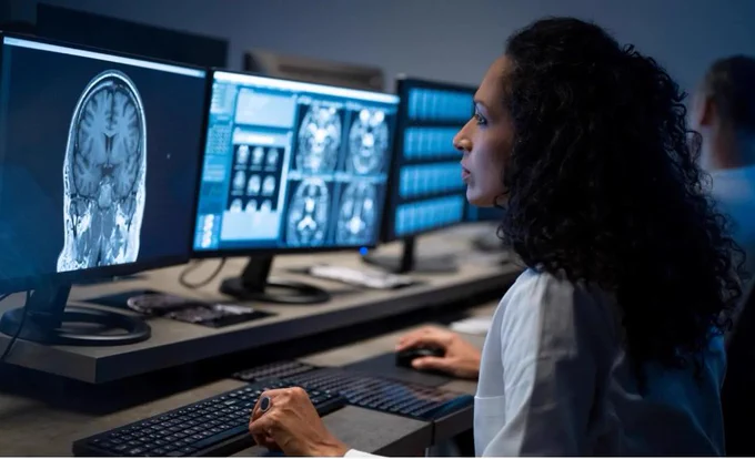 Researcher reviews a brain scan on a computer