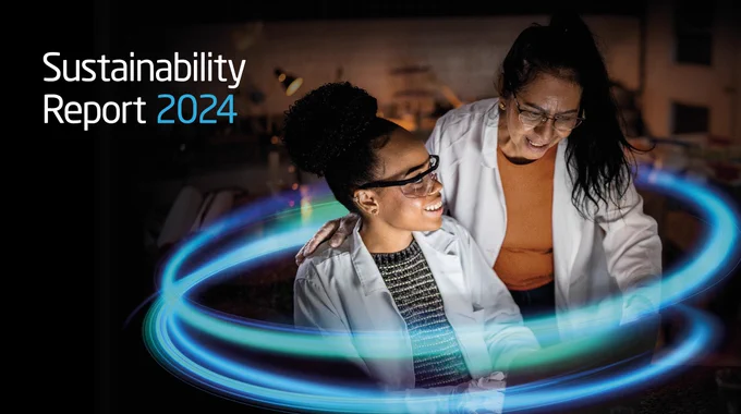 Two individuals review a digital screen with glowing blue light rings, featured in the 'Sustainability Report 2024.'