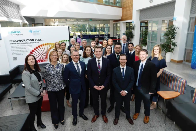 Photograph of Minister Peter Burke, with Dr Darrin Morrissey, CEO NIBRT, and Dr Fiona Killard Lynch, CSO and Director of Research and Innovation, NIBRT and approximately 20 other people at the announcement of €17 million in DTIF funding.  