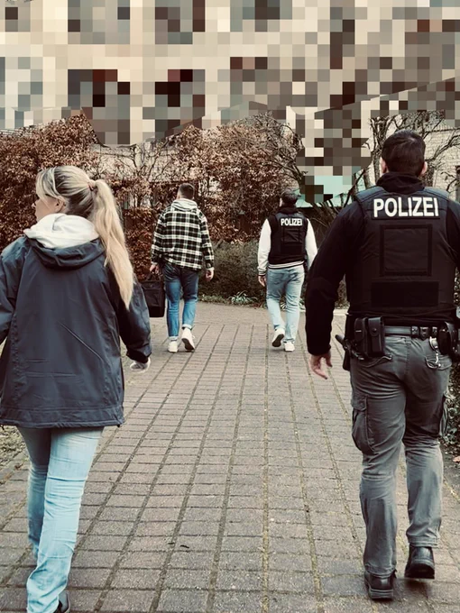 Polizistinnen und Polizisten in Zivil, die auf einem Weg laufen