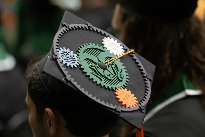 A CSU graduation cap decorated with gears.