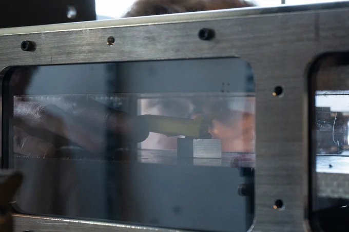 A person placing a model rocket ship in a wind tunnel.
