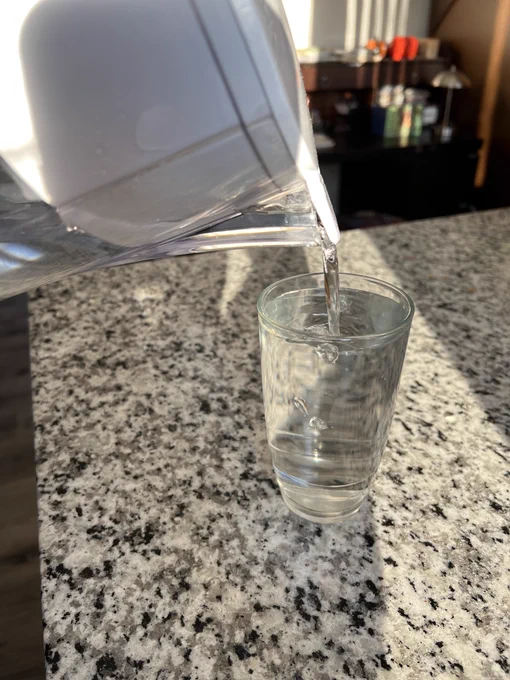 Water is poured from a pitcher to a glass.