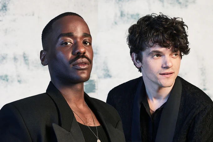 A photo showing two men in blazers in front of a marble background