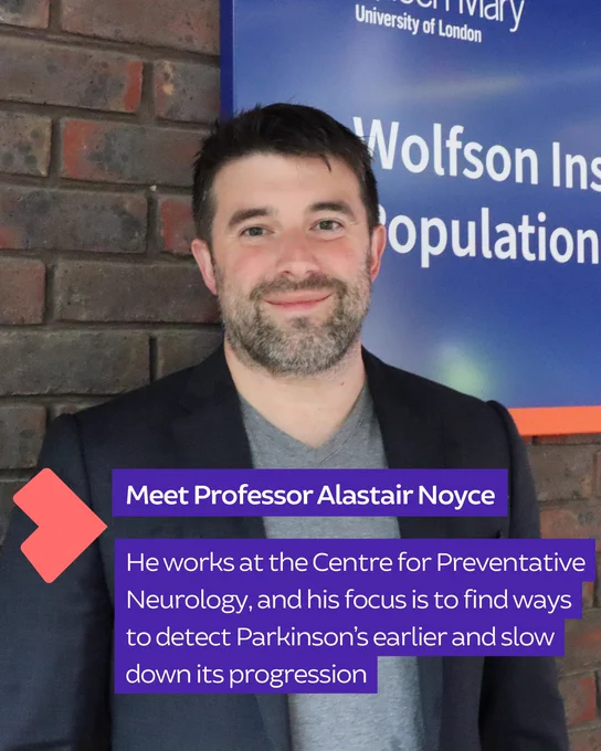 Professor Alastair Noyce stands in front of a Wolfson Institute of Population Health banner, smiling at the camera.