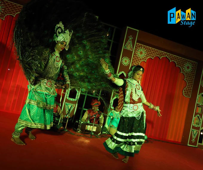 A woman in colorful Rajasthani attire dances on stage at a night performance at Taj Aravali in Udaipur.