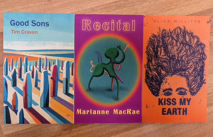 Three books. Tim Craven's features multicoloured gravestones facing a similarly multicoloured landscape. Marianne MacRae's is a purple background with a three legged green creature inside a turquoise circle. And Alice Willitts's is an orange yellow background with a dark blue portrait of a woman with big hair and eyes and the words Kiss My Earth replacing her nose and mouth.