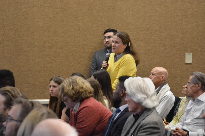An attendee wearing the colors of the Ukrainian flag asks a question