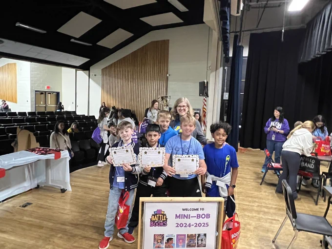Students won first place at the battle of the books pose for a picture.