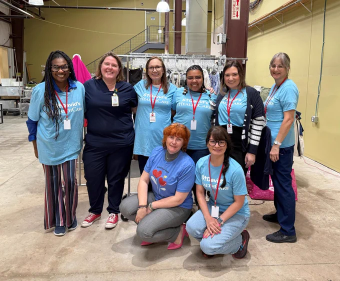 St. David's HealthCare team members gathered as a group in the barn, smiling.