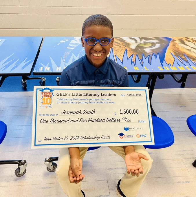 Boy holding a big check