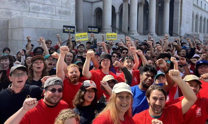 A large group of UAW members posed for a photo with fists raised