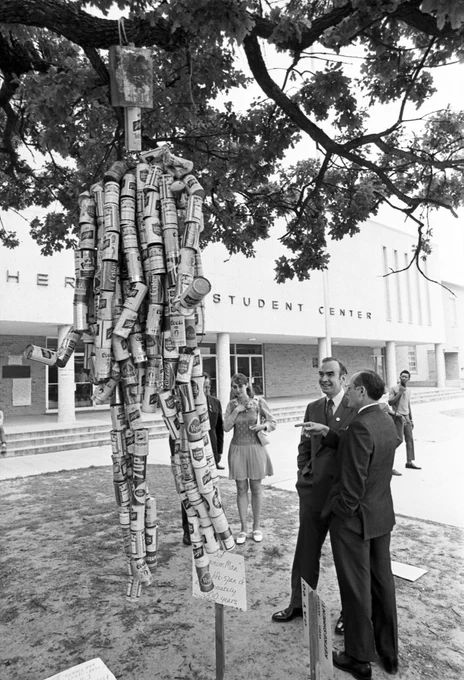 ID: Jim Wright and Frank Harrison admire an “Aluminum Man” sculpture made of aluminum cans on UTA’s campus.]