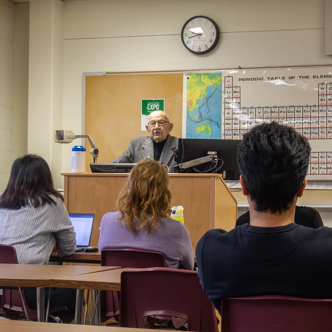 Ron Apanian speaks in front of a class at a podium
