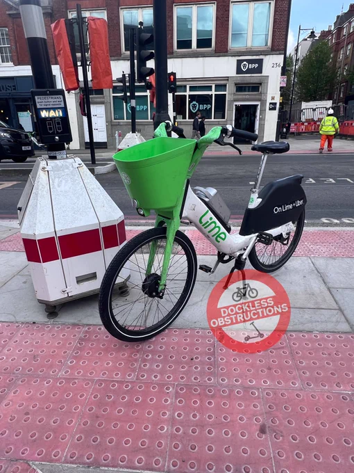 Lime bike parked on pedestrian crossing.
