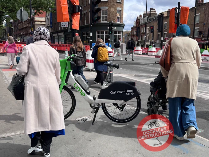 Lime bike parking on pavement during construction works to make road, cycle lanes, pavement and crossings SAFER - wheelchair user has to enter cycle lane to get passed the Lime bike on the pavement.