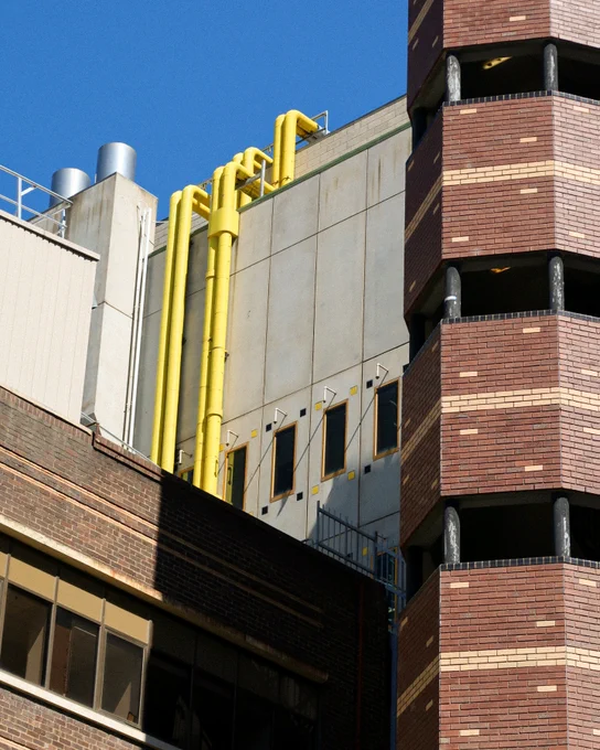 Building 8 exterior, with yellow pipes running down the building. 