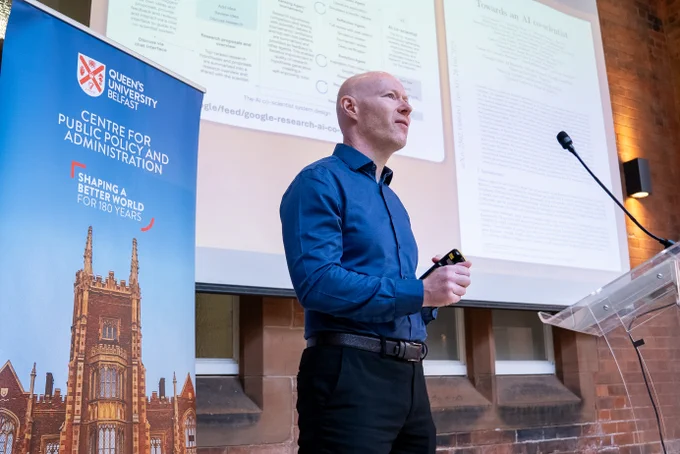 Image shows Professor Phil Hanna speaking on stage.