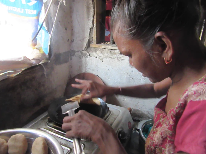 An Indian women cooking Roti.