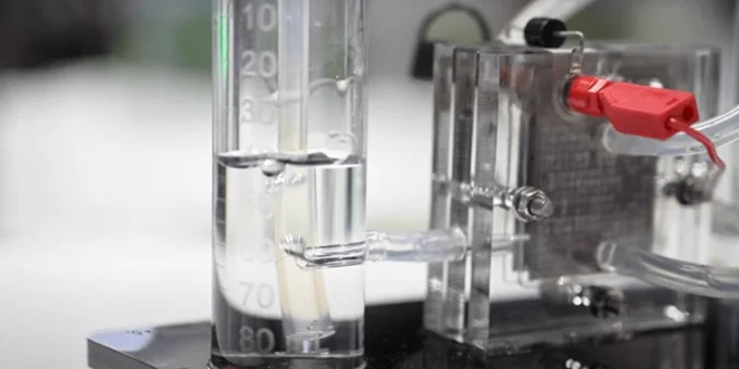 Close-up view of a laboratory setup with measuring cylinders and scientific equipment on a bench.