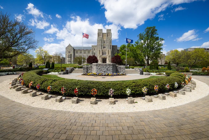 The April 16 Memorial is pictured in front of Burruss Hall against a blue sky.