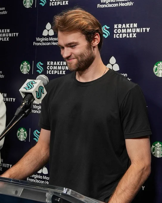 A photo of Shane speaking at the podium.