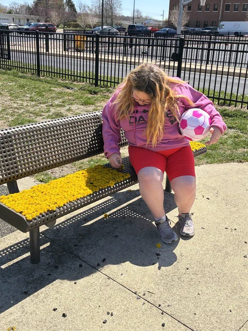 student adds more flowers to the bench