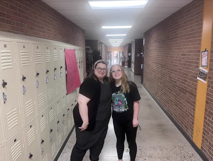 Sarah Miller standing in a school hallway with a student. 