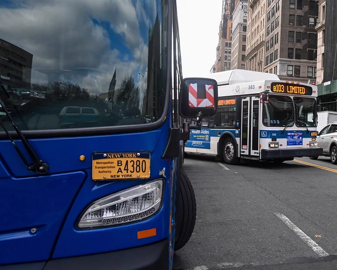 Image of parked bus and B103 Limited bus on street