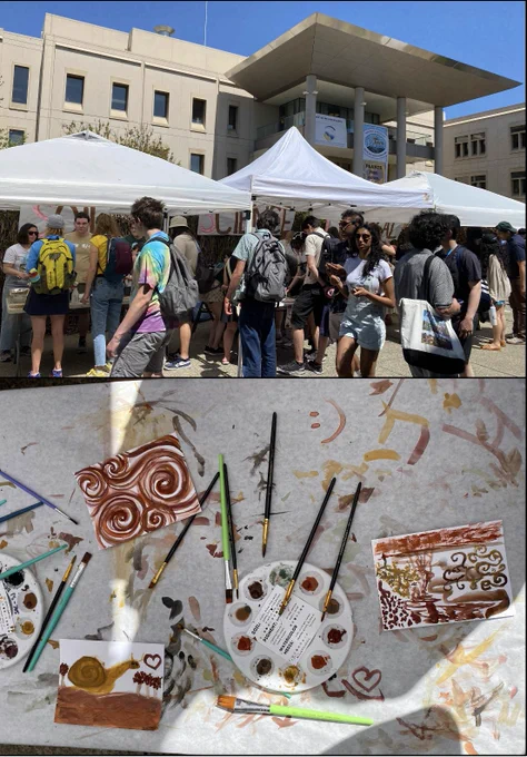 A crowd of visitors are shown engaging with booth activities beneath three white tents. A paint pallet, brushes, and completed paintings are also shown.